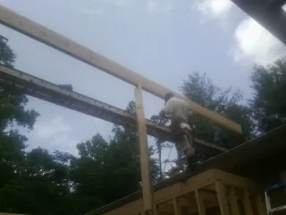 Carpenter setting a ridge beam over a new addition frame — Ice Dam Removal by Roofing Brothers in Wolcottville