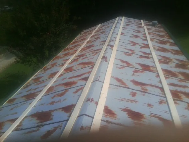 Rusted metal roof panels with new wood purlins before replacement — Storm Damage Roof Repair in Wolcottville by Roofing Brothers