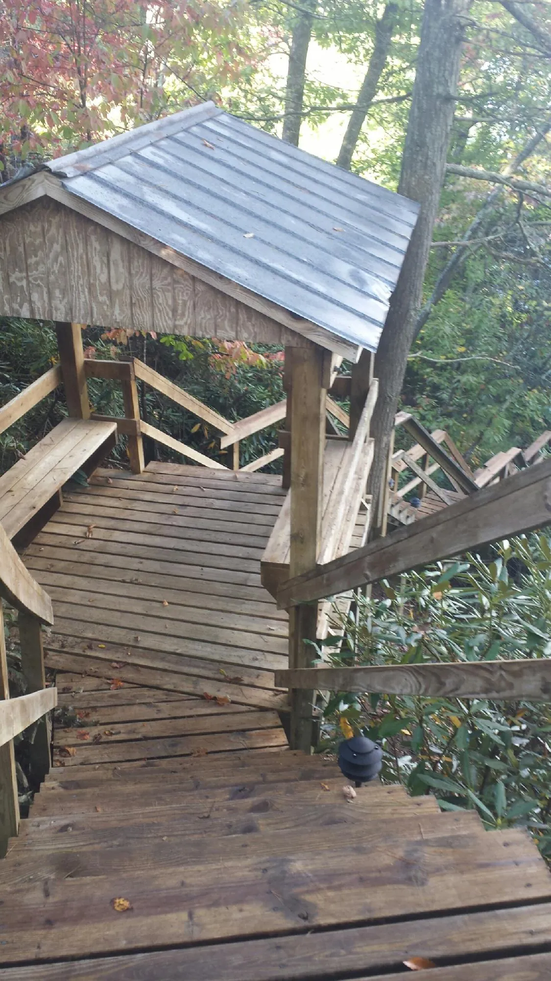 Metal roofed shelter over wooden steps on a wooded walkway — Skylight Repair & Installation work by our crew in Wolcottville