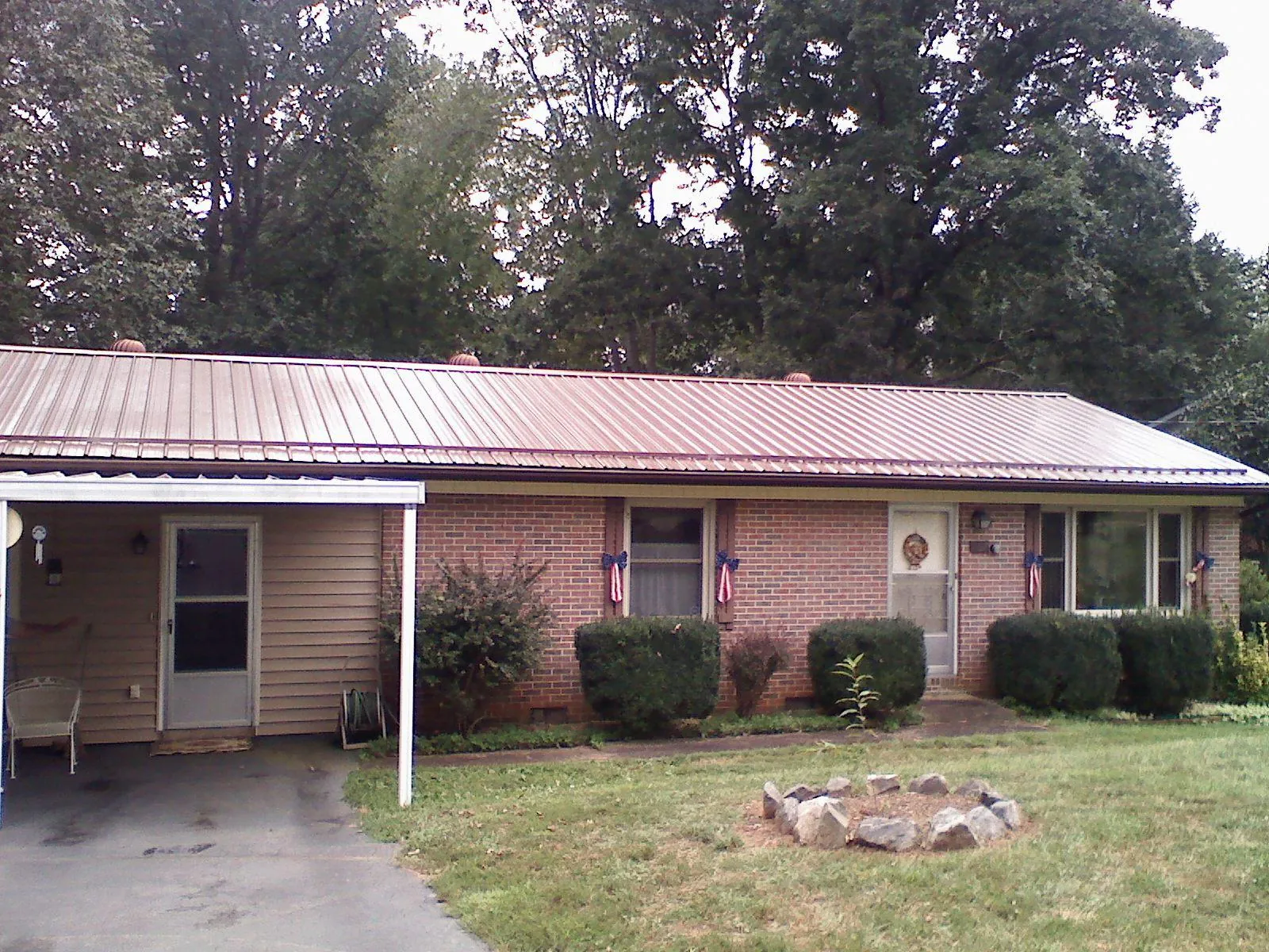 Bronze metal roof and carport on a brick ranch home — Roof Repair work by our crew in Wolcottville